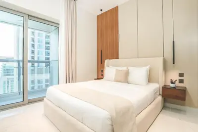a bedroom with a white bed and a large window at Marina Sea View,Elegant and Spacious - High Floor in Dubai