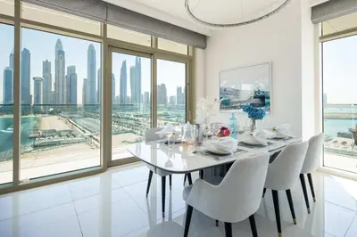 a white dining room with a table and chairs at Frank Porter - Sunrise Tower in Dubai