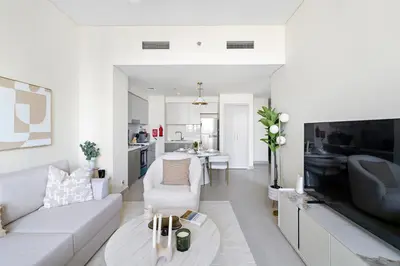 a white living room with a couch and a table at 1BR Forte 2, Skyline City View in Dubai