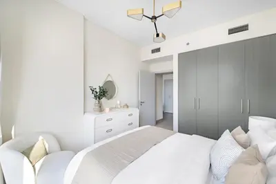 a white bedroom with a large bed and a mirror at 1BR Forte 2, Skyline City View in Dubai