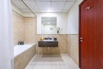 a bathroom with a tub and a sink and a mirror at Family & Group Paradise - JBR Beach 3 min walk - Ain Dubai Views - Heart of JBR - 14 People in Dubai