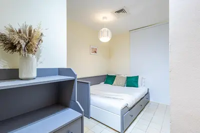 a small room with a bed and a vase at Family & Group Paradise - JBR Beach 3 min walk - Ain Dubai Views - Heart of JBR - 14 People in Dubai