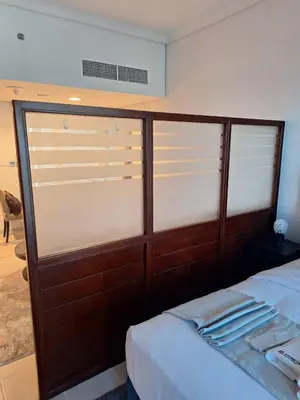 a bedroom with sliding glass doors and a bed at Bright Studio Unit at Lake Terrace with lake view in Dubai