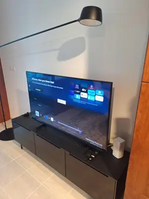 a large flat screen tv sitting on a black entertainment center at Bright Studio Unit at Lake Terrace with lake view in Dubai