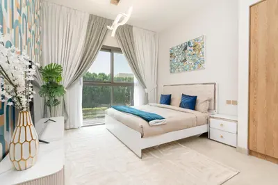 a white bedroom with a bed and a window at Ahlan HH - Stunning Studio in Eleganz 2 Danube, JVC in Dubai