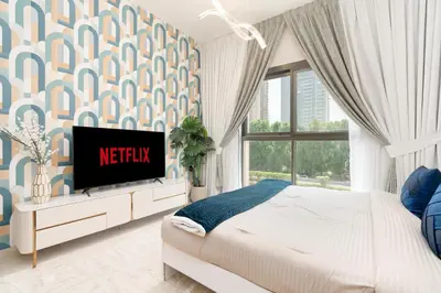 a bedroom with a bed with a tv on a dresser at Ahlan HH - Stunning Studio in Eleganz 2 Danube, JVC in Dubai