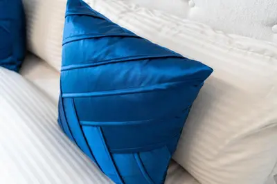 a blue pillow sitting on top of a bed at Ahlan HH - Stunning Studio in Eleganz 2 Danube, JVC in Dubai