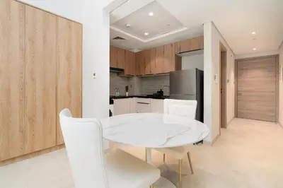 a white dining room with a white table and chairs at Ahlan HH - Stunning Studio in Eleganz 2 Danube, JVC in Dubai