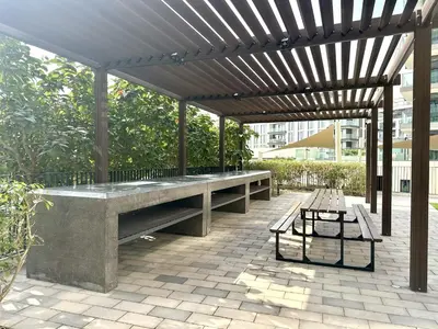 a large stone bench under a wooden pergola at NEW Exceptional Lagoon View - 2 Stylish Bedrooms in Dubai