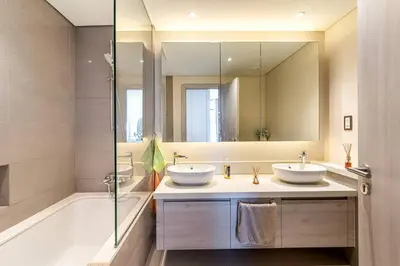 a bathroom with two sinks and a tub and a mirror at NEW Exceptional Lagoon View - 2 Stylish Bedrooms in Dubai