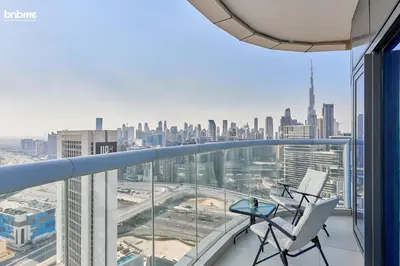 a balcony with two chairs and a view of the city at bnbmehomes - DAMAC Towers Paramount in Dubai