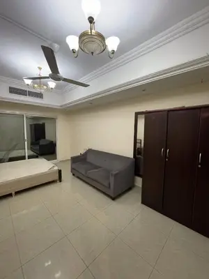 a living room with a couch and a ceiling fan at Lavish Room with family environment in Dubai