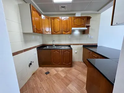 a kitchen with wooden cabinets and a sink at Lavish Room with family environment in Dubai