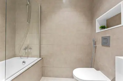 a bathroom with a shower and a toilet and a tub at Superb 1 Bedroom with Burj Khalifa and Lagoon View in Dubai
