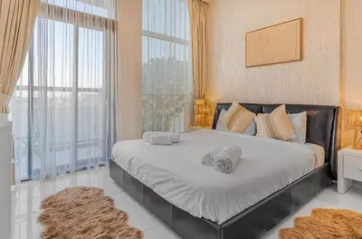 a bedroom with a large bed with towels on it at Trendy Fully Equipped Beautiful Apartment for Four near to Metro in Dubai