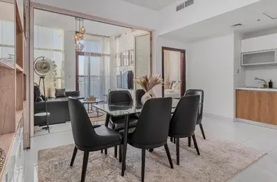 a dining room with a glass table and black chairs at Trendy Fully Equipped Beautiful Apartment for Four near to Metro in Dubai