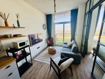 a living room with a couch and a chair at Sunny 1 Bedroom Apartment in Dubai Hills Estate in Dubai