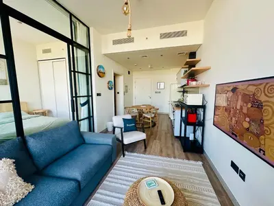 a living room with a blue couch and a table at Sunny 1 Bedroom Apartment in Dubai Hills Estate in Dubai