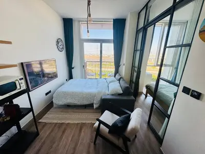 a bedroom with a bed and a living room at Sunny 1 Bedroom Apartment in Dubai Hills Estate in Dubai