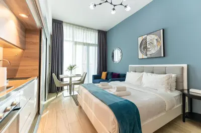 a hotel room with a large bed and a table at Cozy Marina Studio with Partial Sea View in Dubai