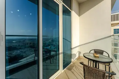 a balcony with a table and chairs and a view at Cozy Marina Studio with Partial Sea View in Dubai