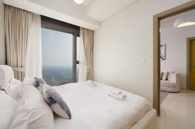 a bedroom with a white bed and a large window at Aykon Luxury Sky Collection Suites with Sea View by HSHOME in Dubai