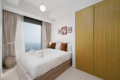 a bedroom with a large bed with a large window at Aykon Luxury Sky Collection Suites with Sea View by HSHOME in Dubai