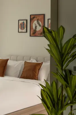 a bedroom with a white bed with pillows and a plant at Aykon Luxury Sky Collection Suites with Sea View by HSHOME in Dubai