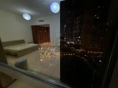 a window with a view of a city at night at HOT MASTER BED ROOM - JBR WALK Marina in Dubai