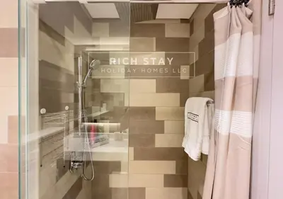 a bathroom with a shower and a sign that reads high stay luxurious homesozy at Seven Palm Escape 1BR in Palm Jumeirah in Dubai