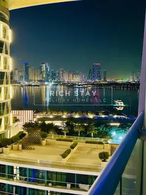a view of a city at night from a balcony at Seven Palm Escape 1BR in Palm Jumeirah in Dubai