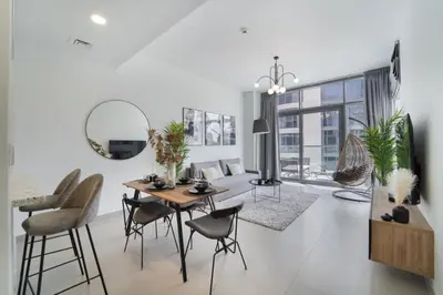 a living room with a dining room table and chairs at HAVN - 1 Bedroom in Downtown, Burj Khalifa View in Dubai