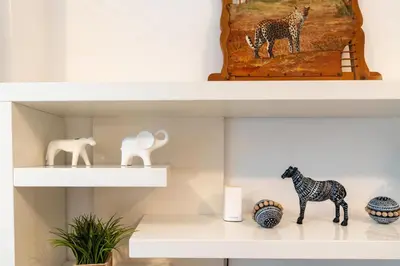 a shelf with figurines of giraffes and animals on it at Vacay Lettings - 1 BHK - Iris Blue Dubai Marina in Dubai
