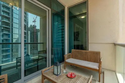 a balcony with a bench and a table on a building at Vacay Lettings - 1 BHK - Iris Blue Dubai Marina in Dubai