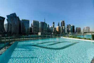 a swimming pool with a city skyline in the background at Burj Khalifa Poolview 1BR Apartment for 4 people in Dubai