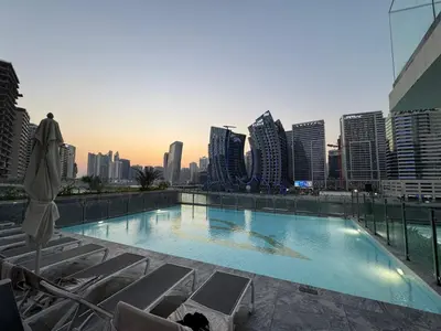 a swimming pool with chairs and a city skyline at Burj Khalifa Poolview 1BR Apartment for 4 people in Dubai