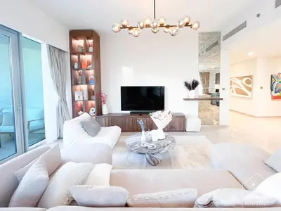 a living room with white furniture and a tv at Luxury Grande Downtown Full Burj khalifa Views in Dubai