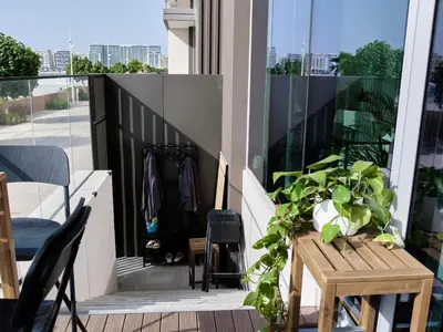 a balcony with a wooden table and a plant at Beachfront Townhouse SEA BREEZE in Dubai