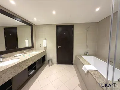 a bathroom with two sinks and a tub and a large mirror at Private Beach - 1-BHK - Palm Jumeirah - Resort in Dubai