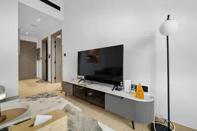 a living room with a television on a white wall at Magnificent - New Modern 1BR in Binghatti Heights in Dubai