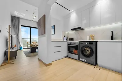a white kitchen with a washer and dryer in it at Magnificent - New Modern 1BR in Binghatti Heights in Dubai