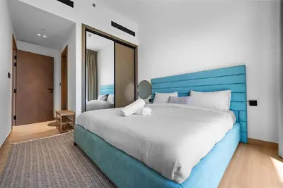 a bedroom with a large bed with a blue headboard at Magnificent - New Modern 1BR in Binghatti Heights in Dubai