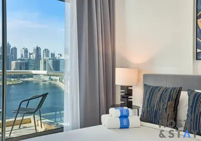 a bedroom with a bed and a window with a view at Stylish Renovated 1-Bedroom in Mayfair Residency in Dubai