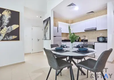 a kitchen and dining room with a table and chairs at Stylish Renovated 1-Bedroom in Mayfair Residency in Dubai
