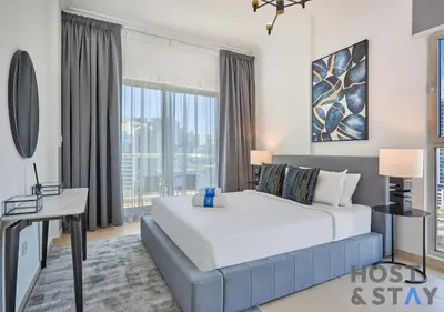 a bedroom with a large white bed and a window at Stylish Renovated 1-Bedroom in Mayfair Residency in Dubai