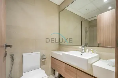 a bathroom with a sink and a toilet and a mirror at Contemporary 2BR in Azizi Park Avenue, Nad Al Sheba by Deluxe Holiday Homes in Dubai