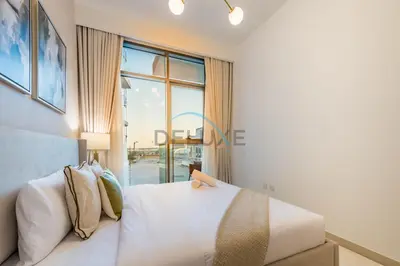 a bedroom with a bed and a large window at Contemporary 2BR in Azizi Park Avenue, Nad Al Sheba by Deluxe Holiday Homes in Dubai