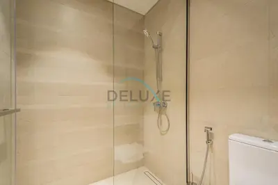 a shower with a glass door in a bathroom at Contemporary 2BR in Azizi Park Avenue, Nad Al Sheba by Deluxe Holiday Homes in Dubai