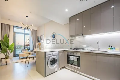 a kitchen with a washer and dryer at Contemporary 2BR in Azizi Park Avenue, Nad Al Sheba by Deluxe Holiday Homes in Dubai