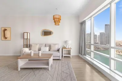 a living room with white furniture and large windows at Superb Marina Views I Sleeps 5 in Dubai